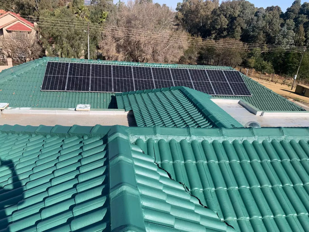 Solar panels installed on a green tiled roof